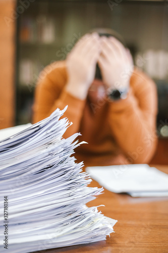 Businessman clutching his head while sitting at a table at work. The concept of depression from difficulties and possible bankruptcy of the enterprise.