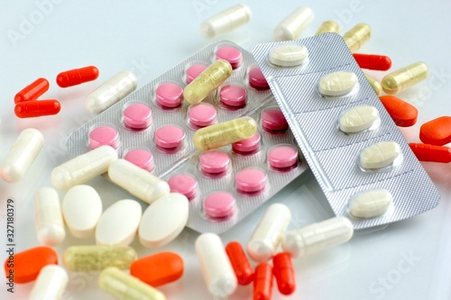 Multicolored pills, tablets against the virus, flu, disease on light background. Medical concept of Virus Pandemic Protection, Coronavirus COVID-19.