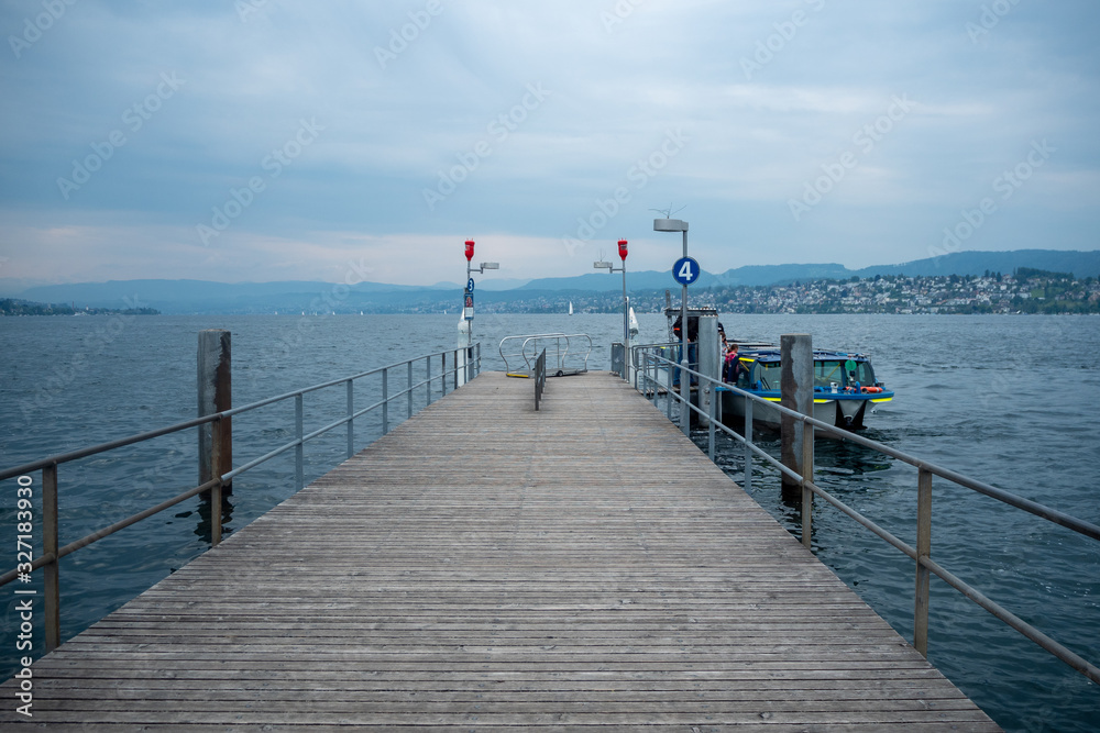 Empty dock with ferry boat at Limmat river with cloudy sky , background , copy space , Zurich , Switzerland