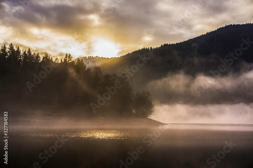 A beautiful misty sunset on the Kruth-Wildenstein Lake in winter  Vosges  France.