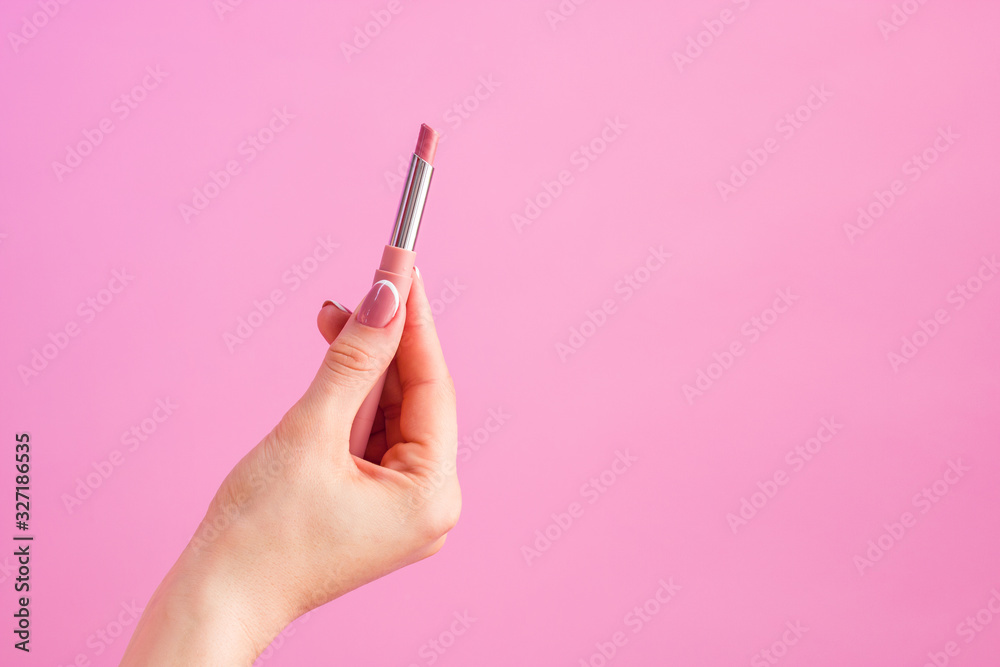 woman hand holding lipstick on pink background copy space woman hand holding lipstick on pink background copy space