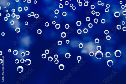 liquid into a glass water bubbles close-up macro background, texture, blue background, bubbles on glass