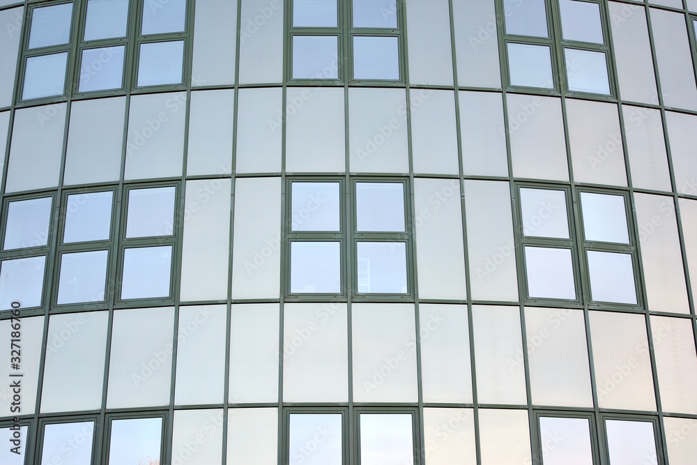 Glass transparent windows on the facade of a modern office or commercial building. Building in the center of a big city reflect the blue sky. Glass transparent windows on the facade of a modern office or commercial building. Building in the center of a big city reflect the blue sky.