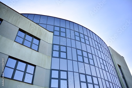 Glass transparent windows on the facade of a modern office or commercial building. Building in the center of a big city reflect the blue sky.