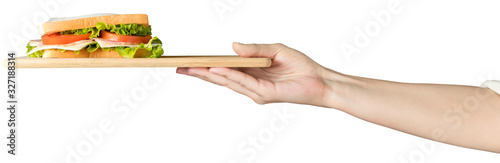 Female hand holds a sandwich with fresh herbs on a wooden tray