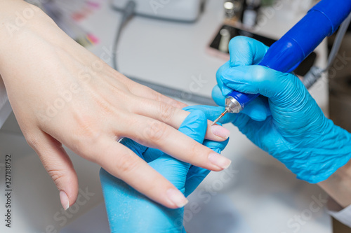 Beauty salon treatment. Manicure. Processing of a cuticle via hardware manicure machine.