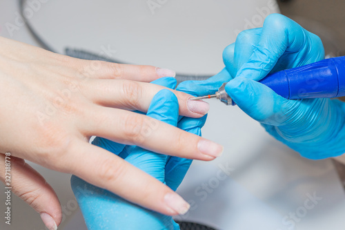 Manicurist doing a Processing of a cuticle treatment.