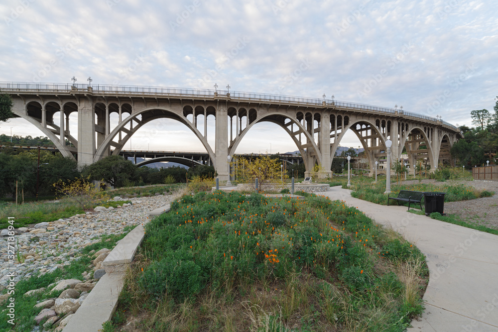 Reginald Desiderio Park in Pasadena and the Colorado Street bridge over the Arroyo Seco. Image taken at dusk. Golden poppies are seen in the foreground. Reginald Desiderio Park in Pasadena and the Colorado Street bridge over the Arroyo Seco. Image taken at dusk. Golden poppies are seen in the foreground.