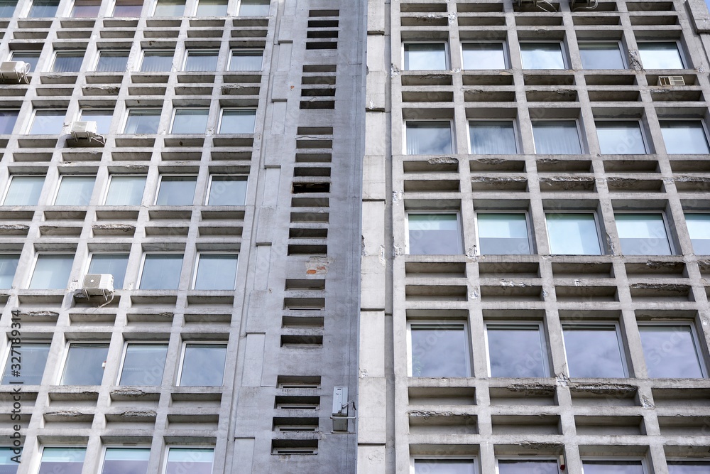 Facade of an old industrial office building with a predominance of old cement and old structural elements. Facade of an old industrial office building with a predominance of old cement and old structural elements.