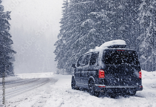 Modern car on snowy road near forest. Winter vacation