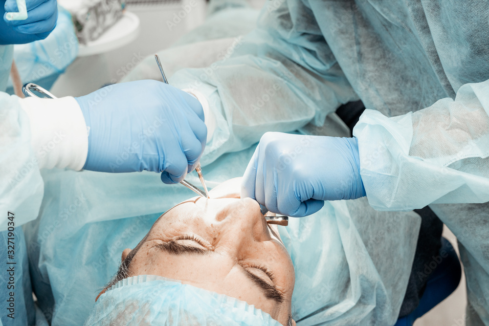Dentists will perform an operation, implant placement. Real operation. Tooth extraction, implants. Professional uniform and equipment of a dentist. Healthcare Equipping a doctor’s workplace. Dentistry Dentists will perform an operation, implant placement. Real operation. Tooth extraction, implants. Professional uniform and equipment of a dentist. Healthcare Equipping a doctor’s workplace. Dentistry