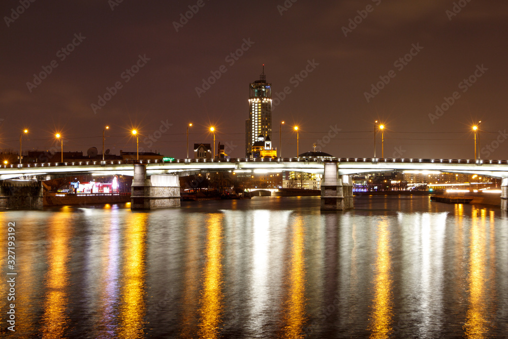 Night view of the Novospassky bridge, the reflection of city lights in the river.