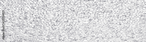 White rough stone wall wide large texture. Whitewashed crushed rock surface long panoramic background