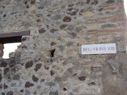 Tablou pe pânză A stone penis on the wall of a building in Pompeii, Italy pointing the way to th