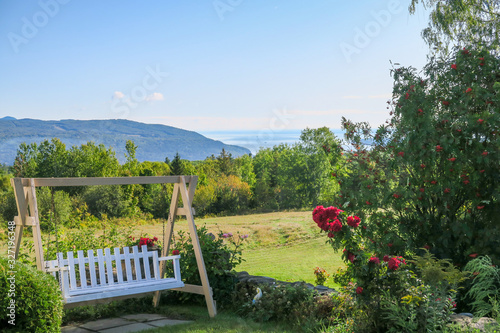 Charlevoix  Canada  Beautiful garden with a wooden swing and the st Lawrence river in the background