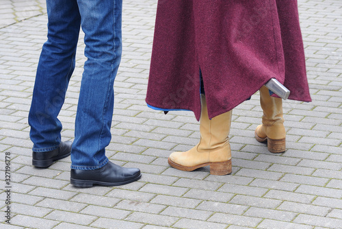 Two men, one in modern jeans and boots, the second in medieval boots and a cape. The second sword in the scabbard