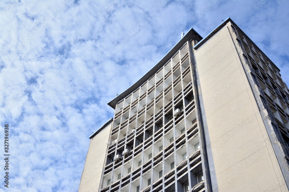 Facade of an old industrial office building with a predominance of old cement and old structural elements.