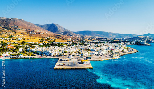 Small costal village aerial view from above. Fascinating landscape of village by the sea with mountains on the background, Paros, Greece