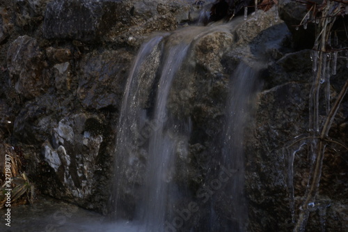 Water from a flowing stream and frozen grass