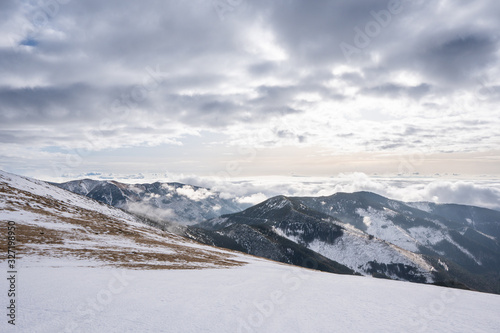 Snow covered mountains with clouds and mist in valley, Low Tatras Dumbier, Slovakia