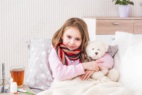 Fototapeta Naklejka Na Ścianę i Meble -  Little ill girl with scarf with teddy bear