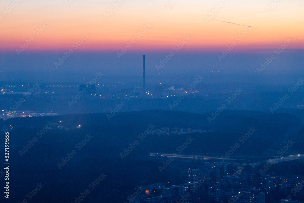 View from the TV tower to the city below. Vilnius TV Tower. City at sunset. Power station at sunset. Sunset on the horizon. Yellow sky View from the TV tower to the city below. Vilnius TV Tower. City at sunset. Power station at sunset. Sunset on the horizon. Yellow sky