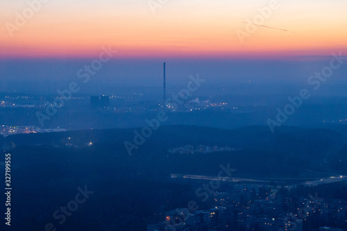 View from the TV tower to the city below. Vilnius TV Tower. City at sunset. Power station at sunset. Sunset on the horizon. Yellow sky