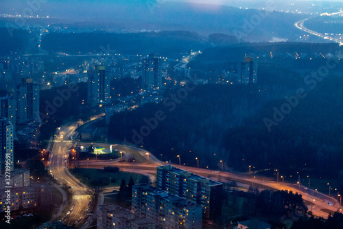The view from the television tower to the city below. The areas of Vilnius. Buildings and streets. Vilnius TV tower. City at sunset.