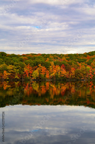 Colorful and autumnal trees reflecting in the water, at the St Bruno national park, Quebec