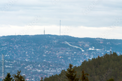 Holmenkollen ski jump and Tryvann towers and tv-antenna in Oslo, Norway. Picture taken from distance with tele zoom..Traveling and city concept. photo