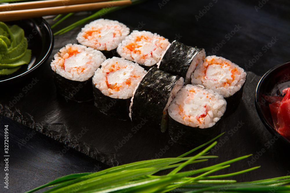 Set of sushi rolls with wasabi and ginger on a black background. Japanese oriental cuisine Set of sushi rolls with wasabi and ginger on a black background. Japanese oriental cuisine