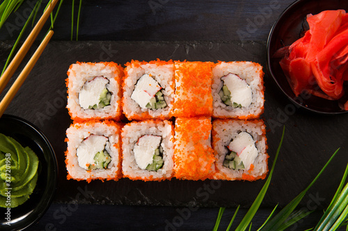 Set of sushi rolls with wasabi and ginger on a black background. Japanese oriental cuisine
