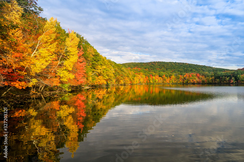 Colorful and autumnal trees reflecting in the water, at the St Bruno national park, Québec