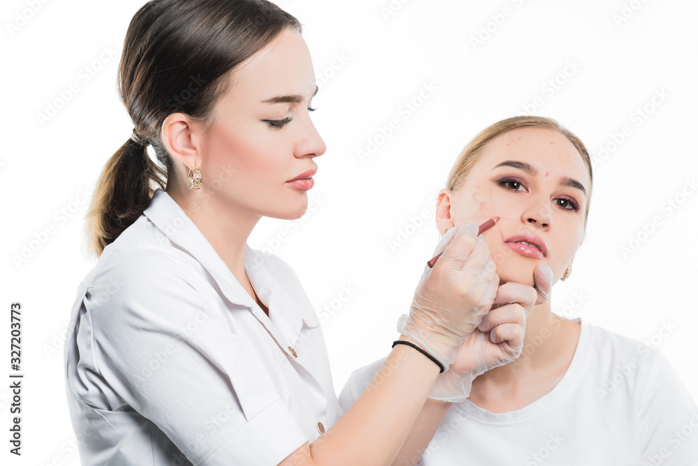 A cosmetologist examines the patient face and plans to perform a series of cosmetic procedures A cosmetologist examines the patient face and plans to perform a series of cosmetic procedures
