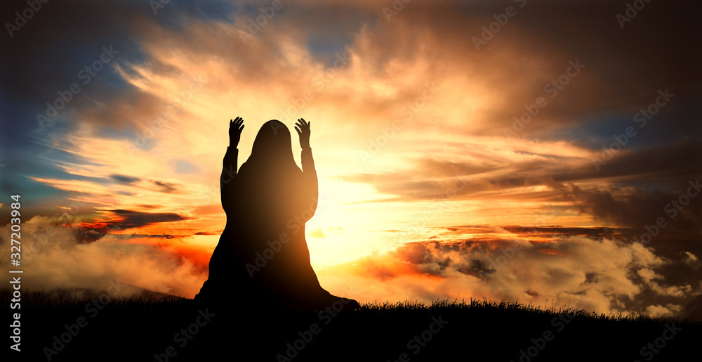 silhouette of a Muslim woman praying at sunset - obrazy, fototapety, plakaty 