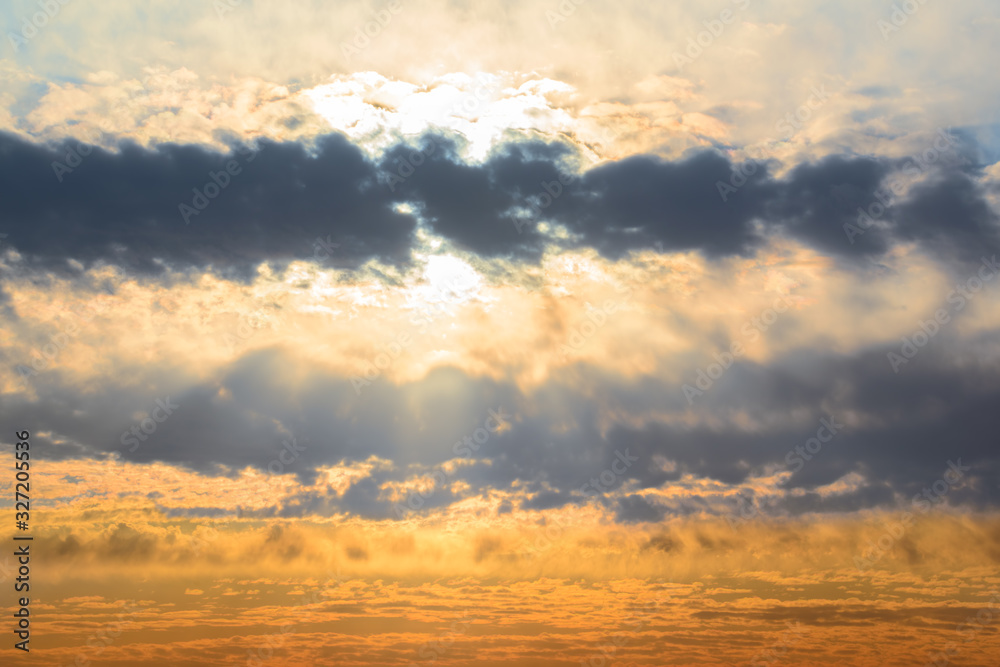 Fototapeta premium Beautiful sunset sky. Sun through dark thick fluffy clouds natural sunset sky view background.