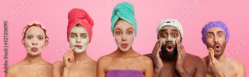 Shocked women and men of different races wear applied face masks, have beauty treatments after taking shower, listen advice of cosmetologist, stand next to each other, express wonder and say omg