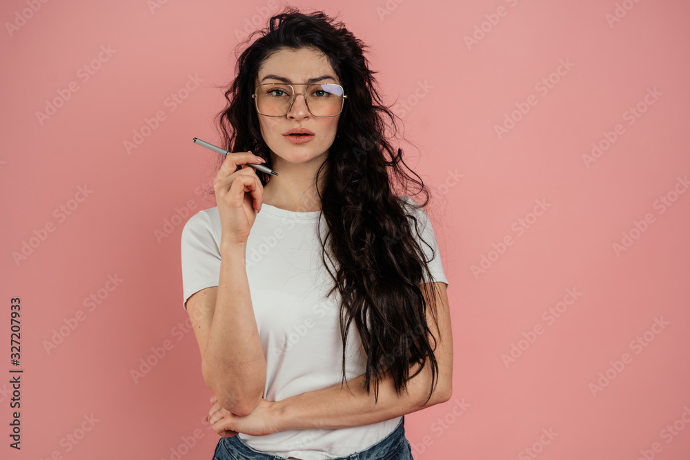 Fototapeta premium Portrait of a young girl on a pink background