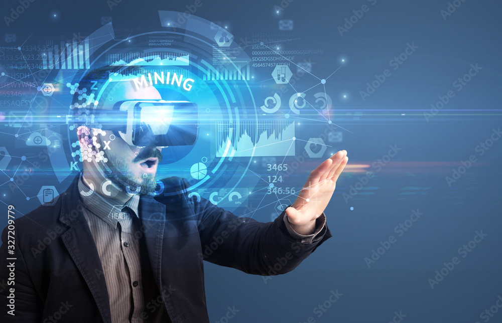 Businessman looking through Virtual Reality glasses with MINING inscription, innovative technology concept Businessman looking through Virtual Reality glasses with MINING inscription, innovative technology concept