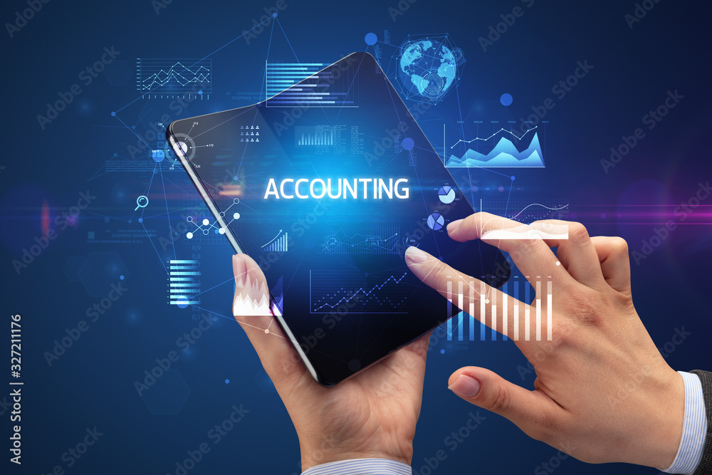 Businessman holding a foldable smartphone with ACCOUNTING inscription, successful business concept Businessman holding a foldable smartphone with ACCOUNTING inscription, successful business concept