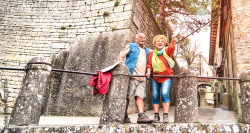 Senior retired couple having genuine fun in San Marino old town castle - Active elderly and travel lifestyle concept with mature people at italian roadtrip - Warm bright filter with soft sunshine halo