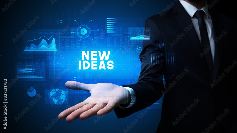 Hand of Businessman holding NEW IDEAS inscription, business success concept Hand of Businessman holding NEW IDEAS inscription, business success concept
