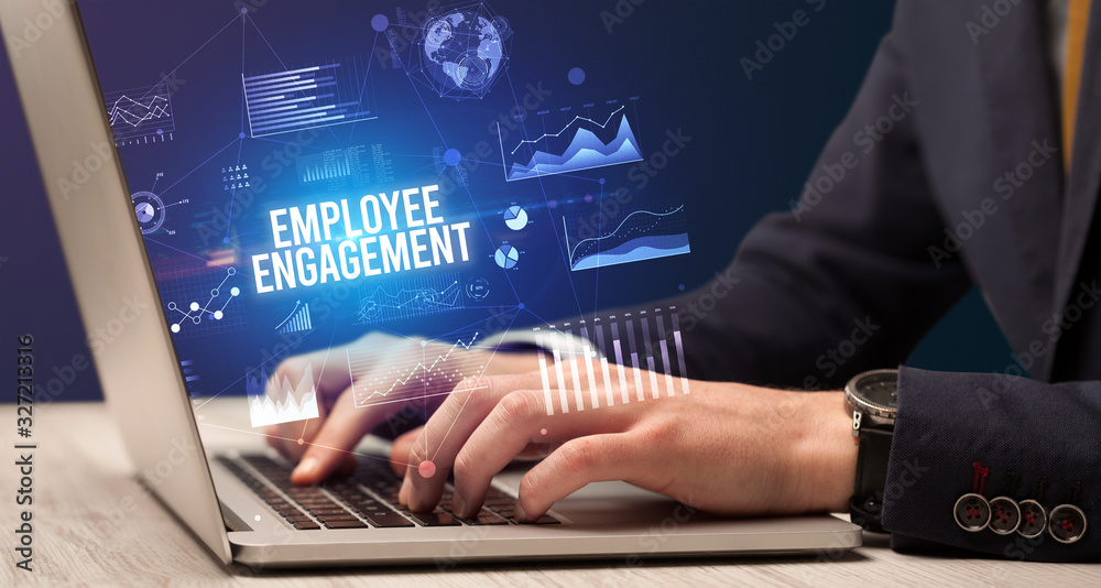 Naklejka premium Businessman working on laptop with EMPLOYEE ENGAGEMENT inscription, new business concept