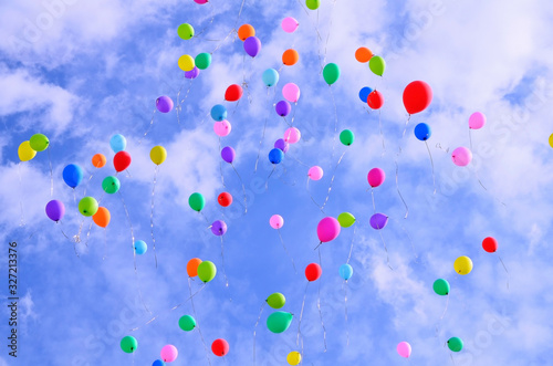 multicolored balloons on a blue sky with clouds. holiday, joy, mood.