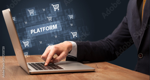 Businessman working on laptop with PLATFORM inscription, online shopping concept