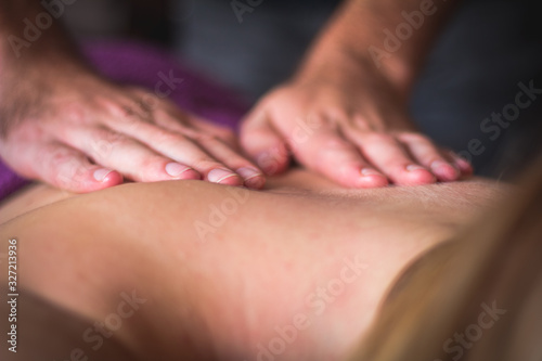 Male therapist tapping young woman s skin during massage
