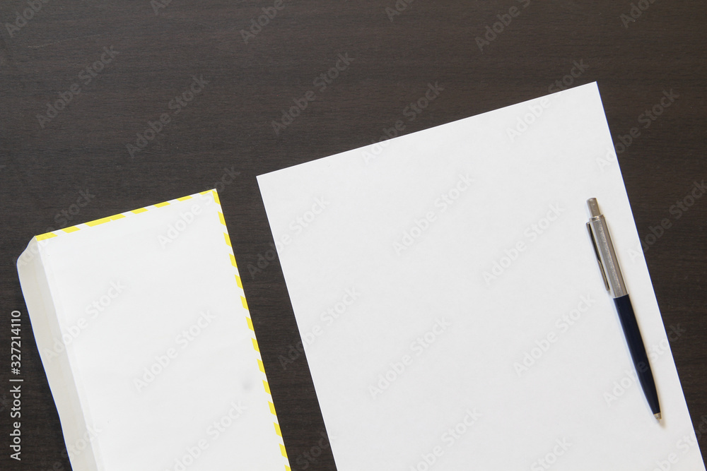Template of white paper with pen and envelope on dark wenge color wooden background. Template of white paper with pen and envelope on dark wenge color wooden background.