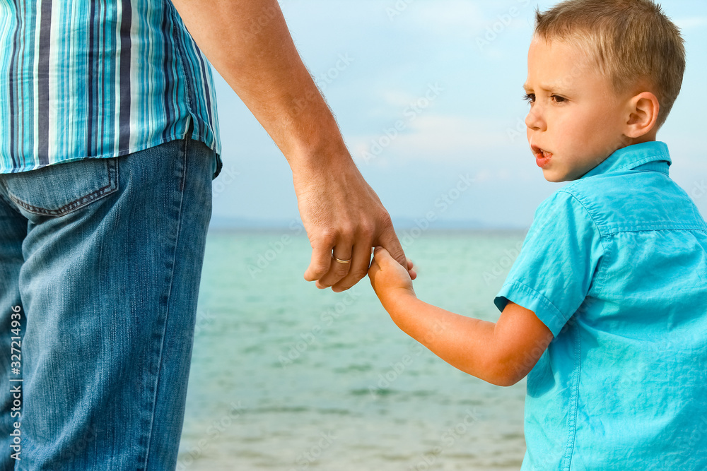 hands of happy parent and child at sea greece background hands of happy parent and child at sea greece background