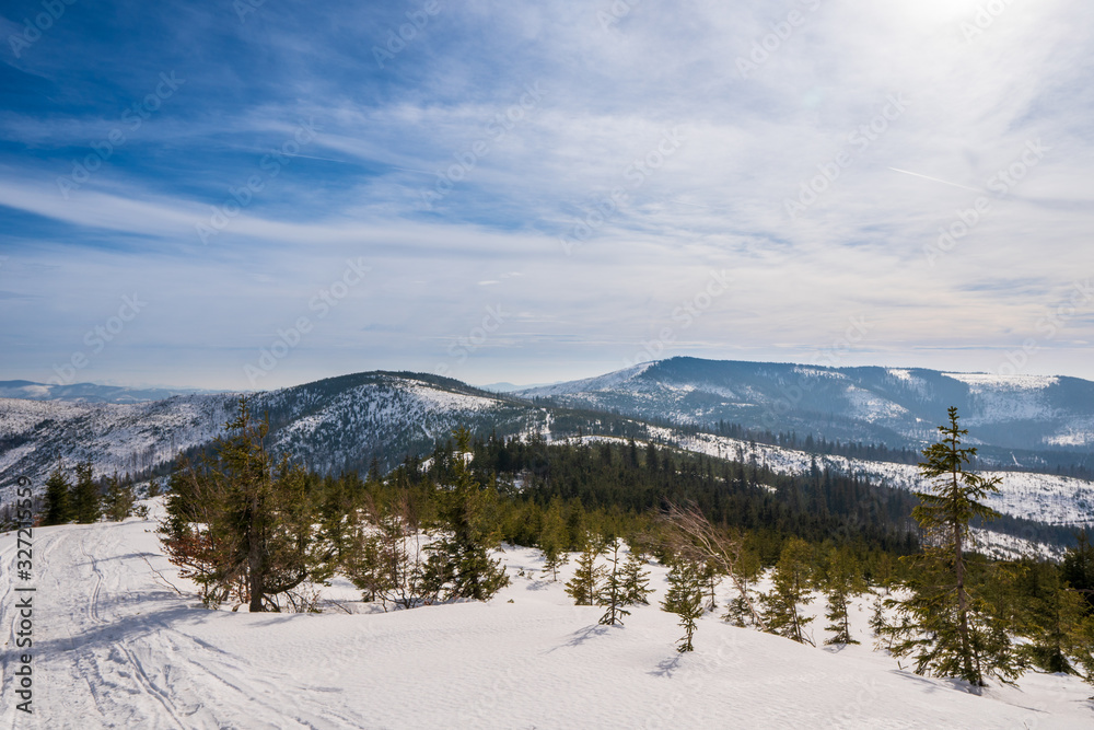Winter landscape in mountains at sunshine day with beautiful clouds, Poland Beskids