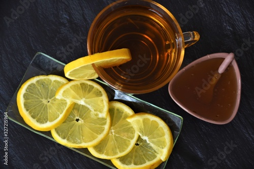 tea with lemon in a glass goblet and honey in a small bowl